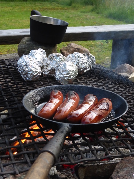 sausages cooking in a campfire